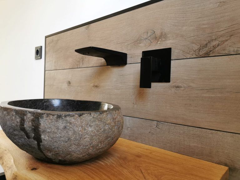 Waschbecken in Naturstein auf Fliesen in Holzoptik