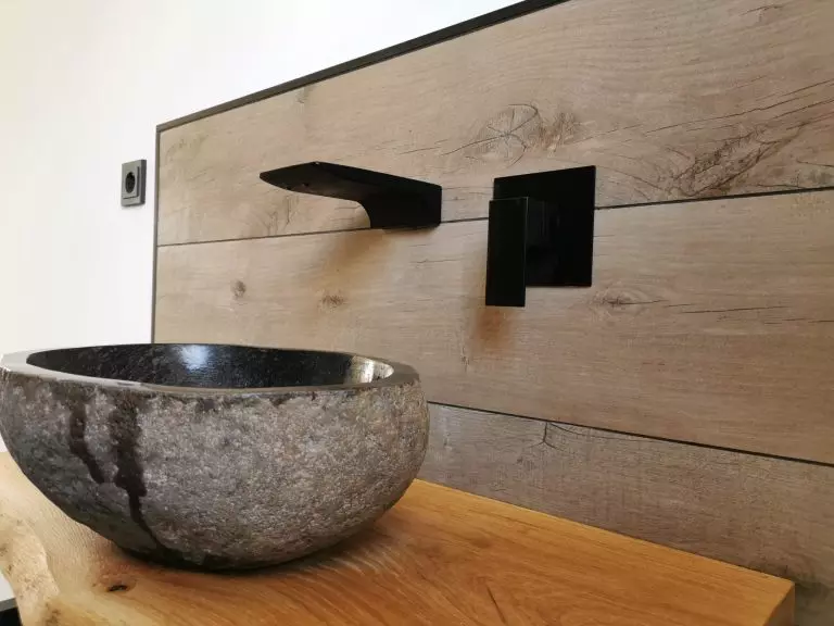 Waschbecken in Naturstein auf Fliesen in Holzoptik